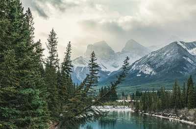 Peaceful Canmore scene with a winding river and majestic mountains—ideal for a tranquil escape.