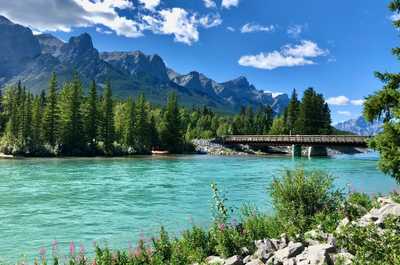 "Scenic Canmore bridge over a turquoise river—perfect for a stroll and photos.