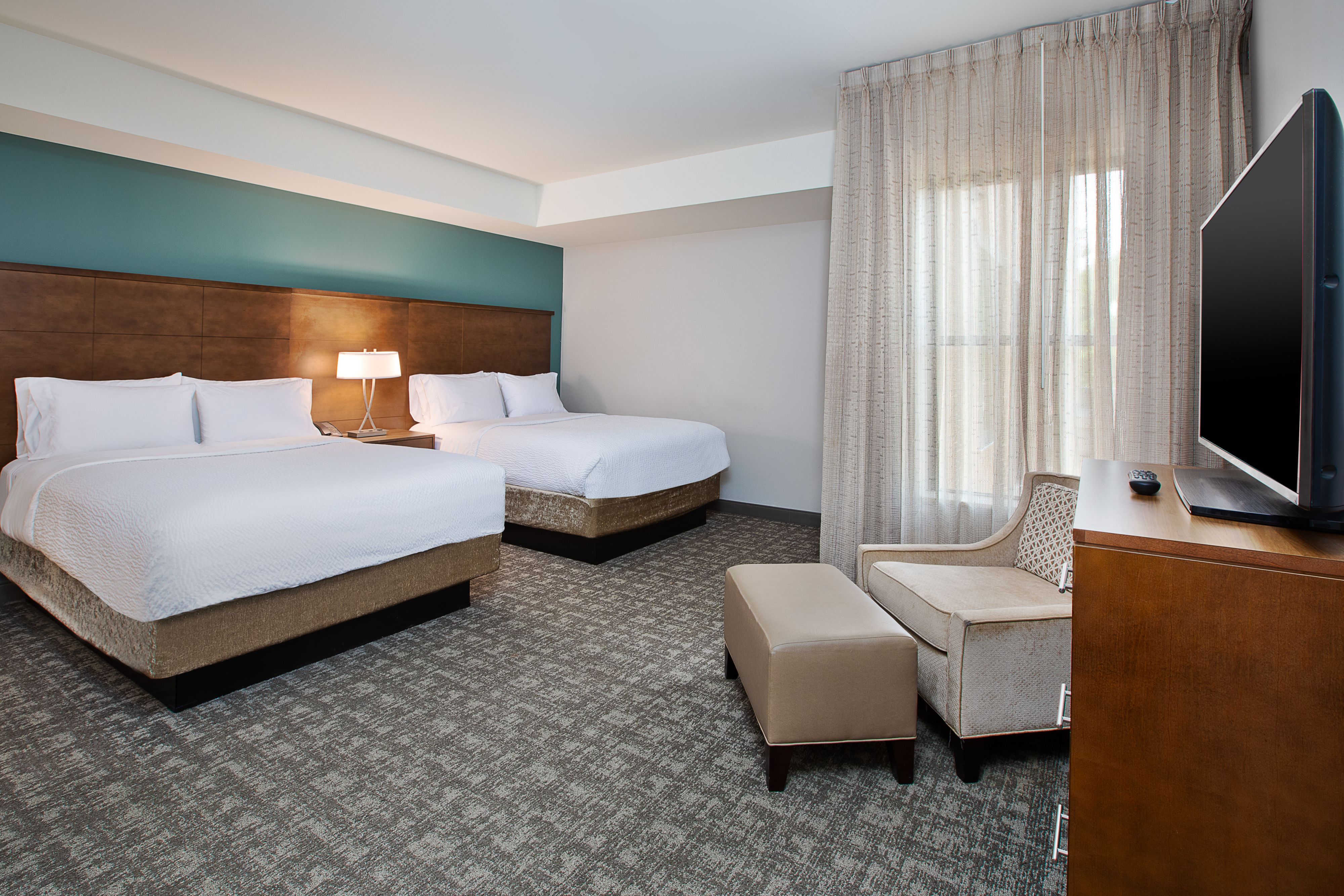 image Bedroom with two queen beds, flat-screen TV, and seating.