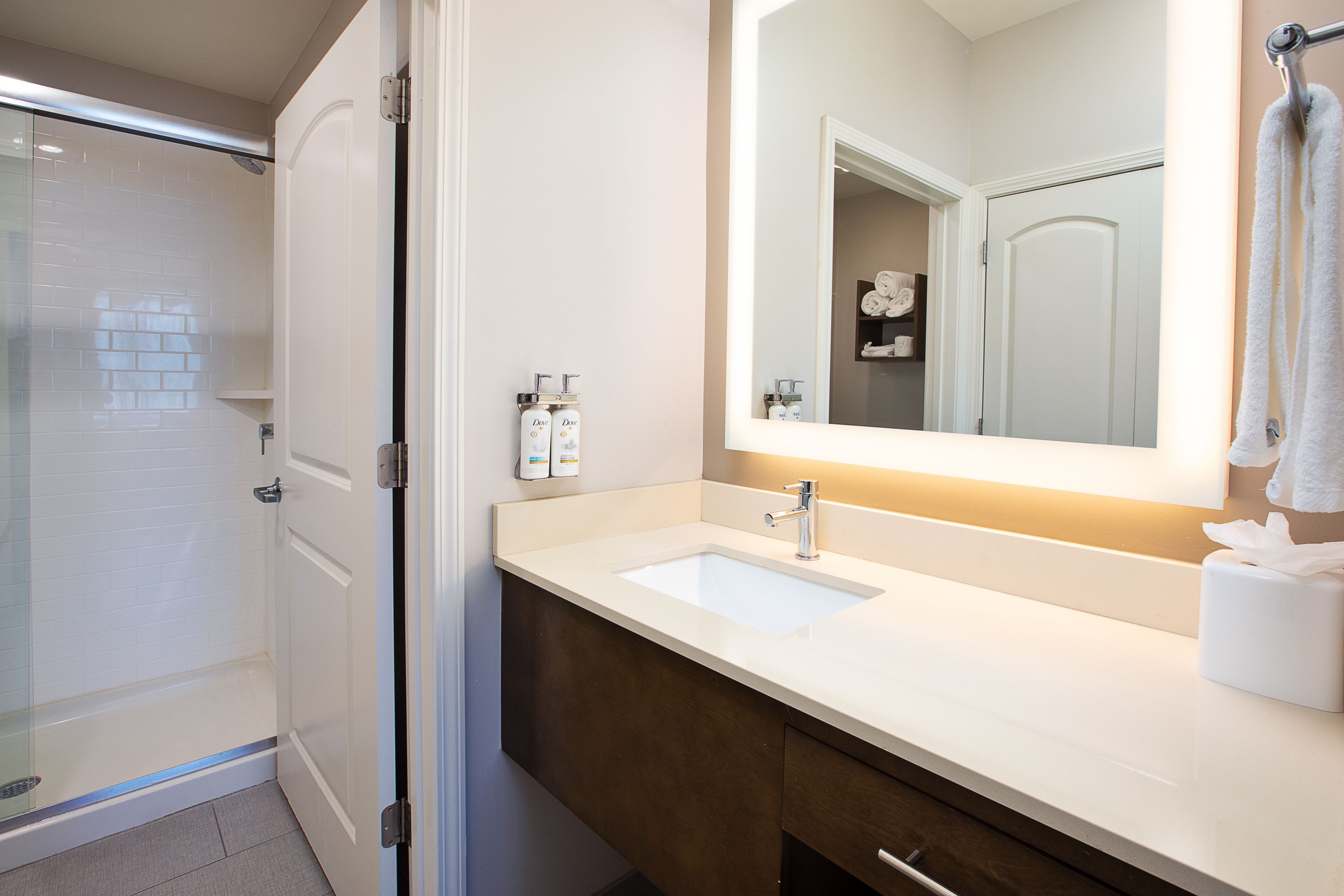 image Bathroom with walk-in shower, sink, and fresh towels.