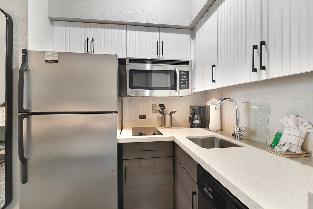 image Gather around the sleek kitchenette, complete with stylish storage and cooking essentials for your culinary adventures.