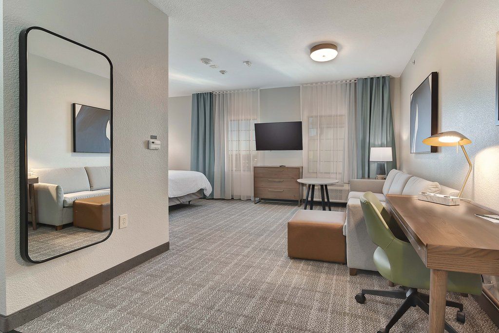 image Step into a bright living space, featuring cozy seating and a sleek workspace, perfect for your stay.