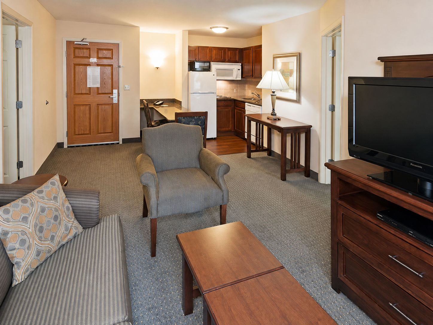 image Living area with seating, dining table, and kitchen.