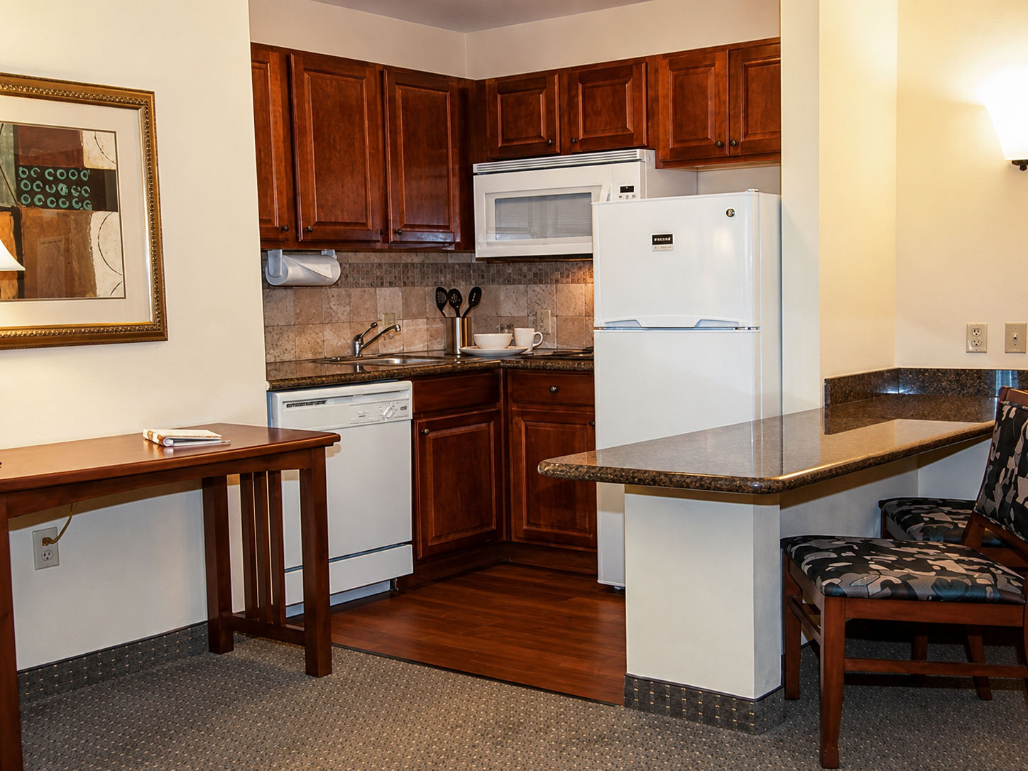 image Kitchen with wooden cabinets, appliances, and dining area.