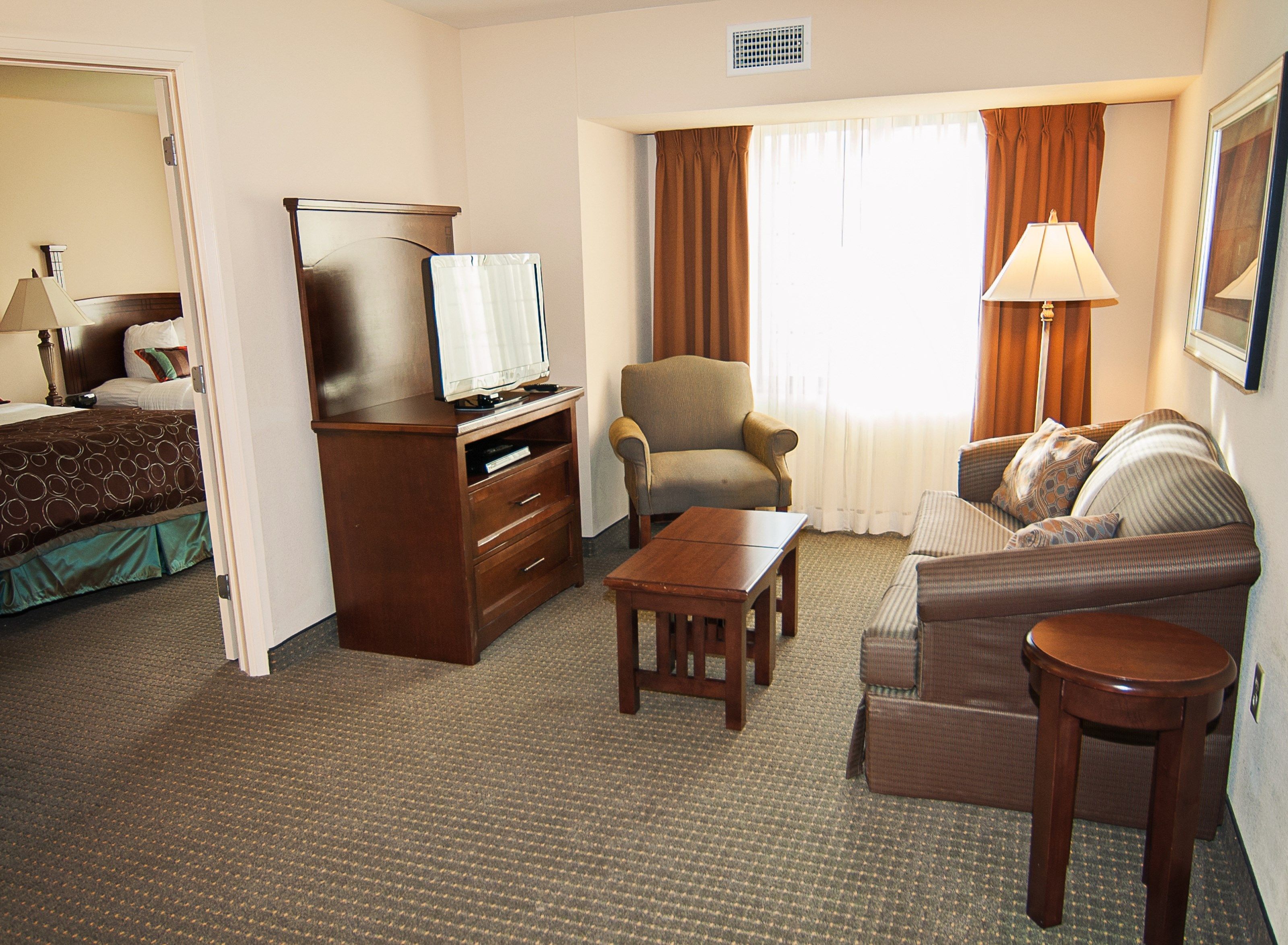 image Living area with sofa bed, armchair, TV, and light source.