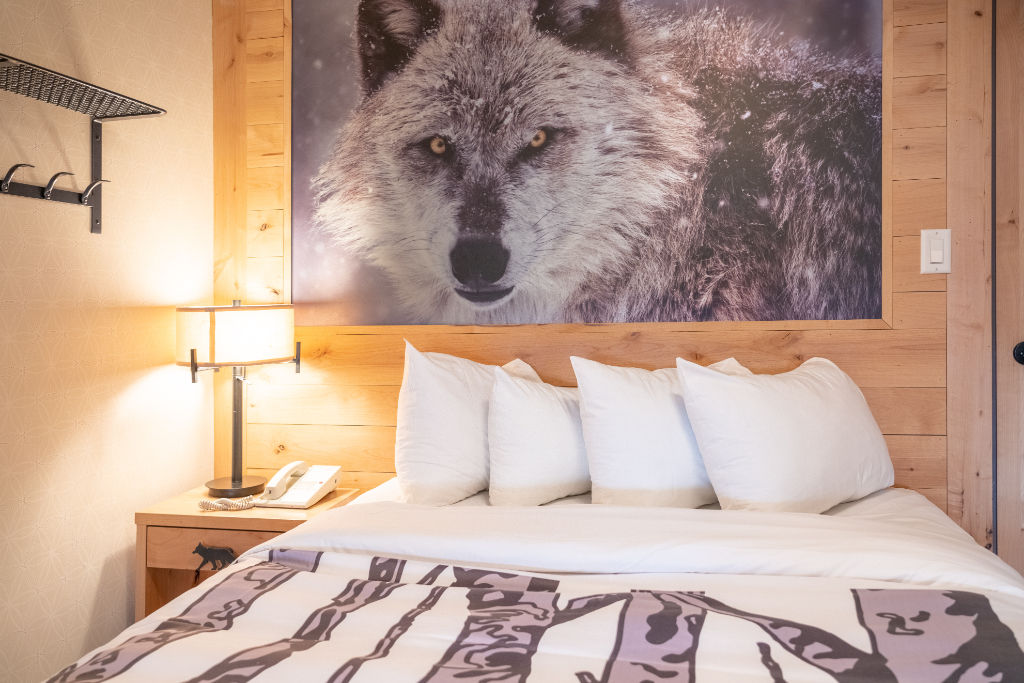 image A bedroom featuring a striking wall mural and plush bedding.