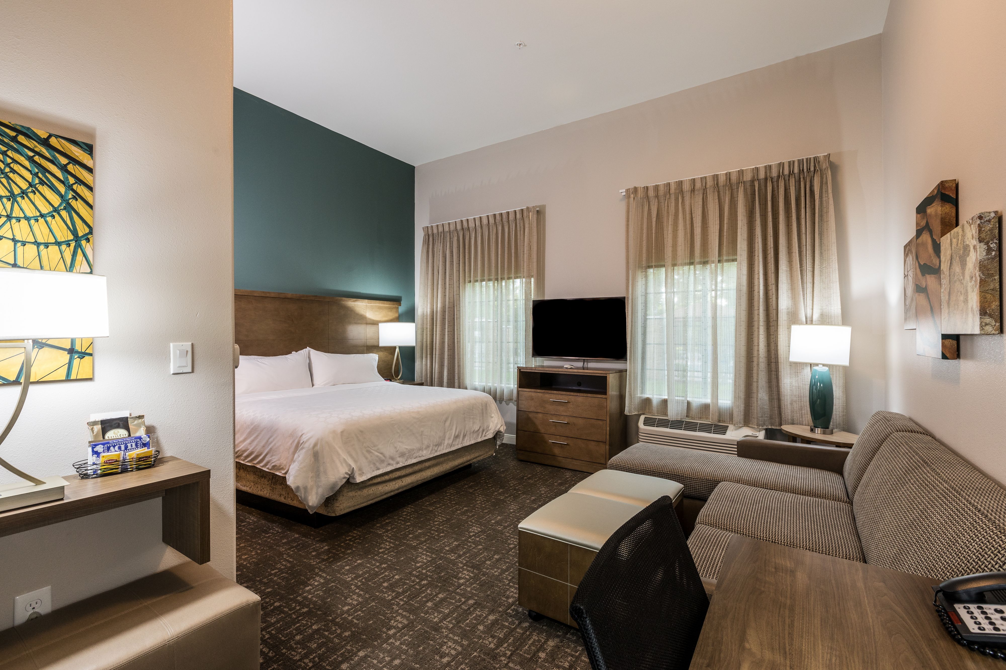 image Open guest suite with a bed, TV, and comfortable seating.