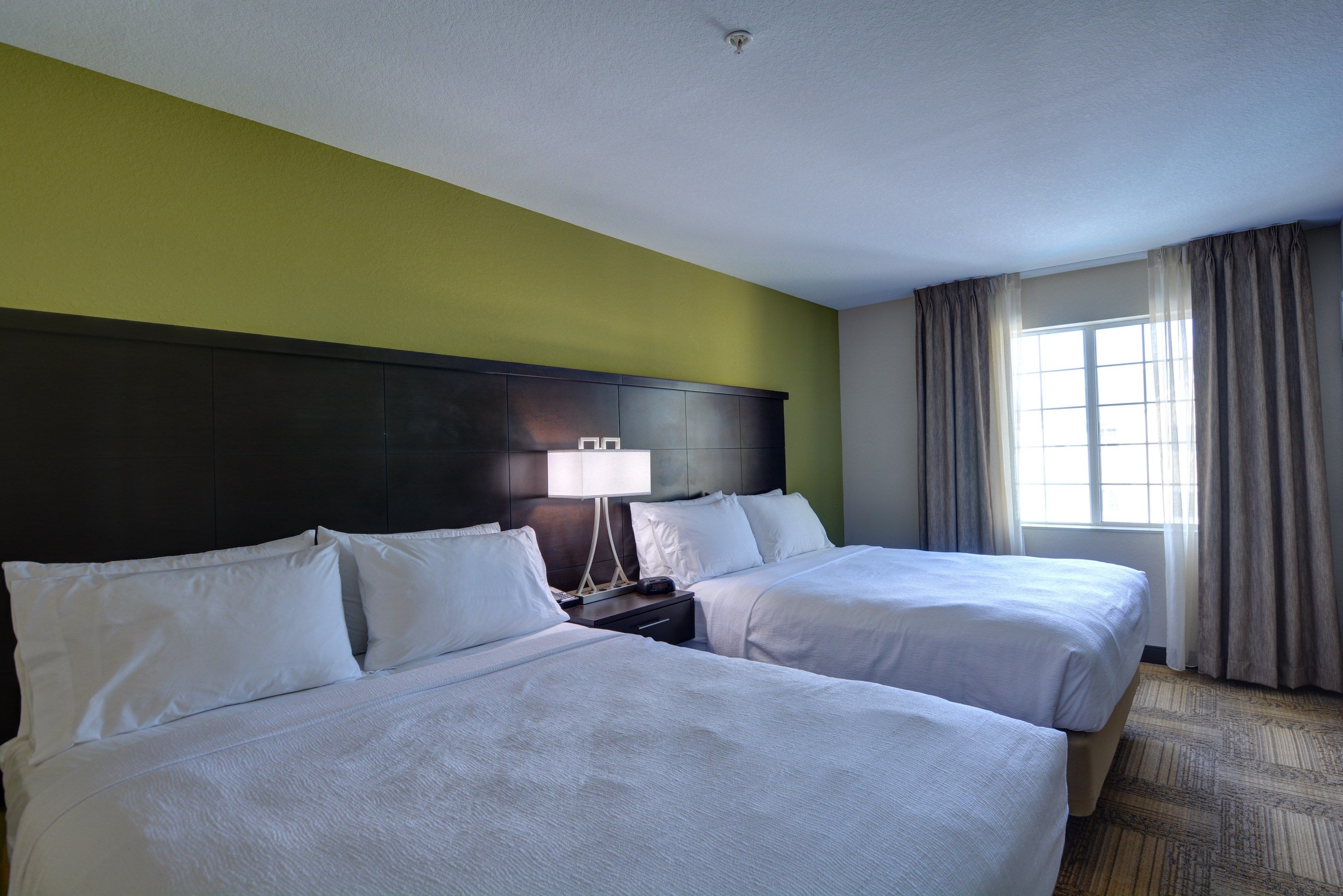 image Second bedroom with two double beds and natural light from the window.