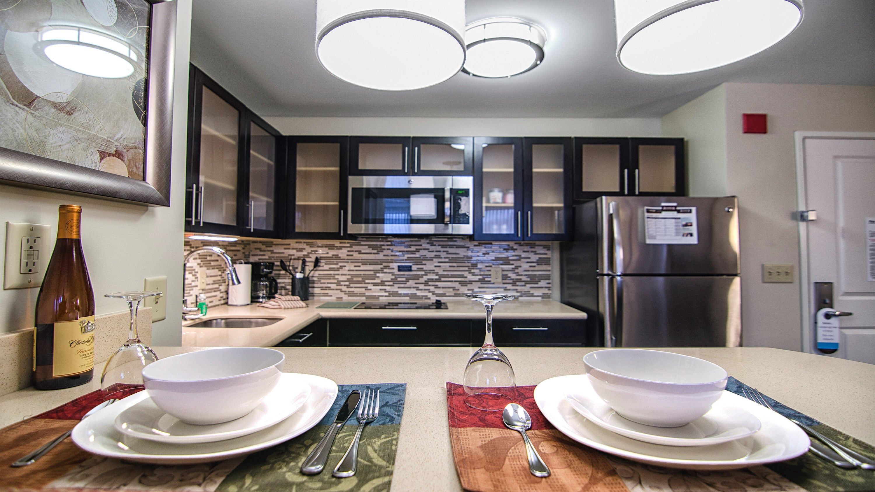 image Elegant kitchen dining setup with tableware and counter seating.