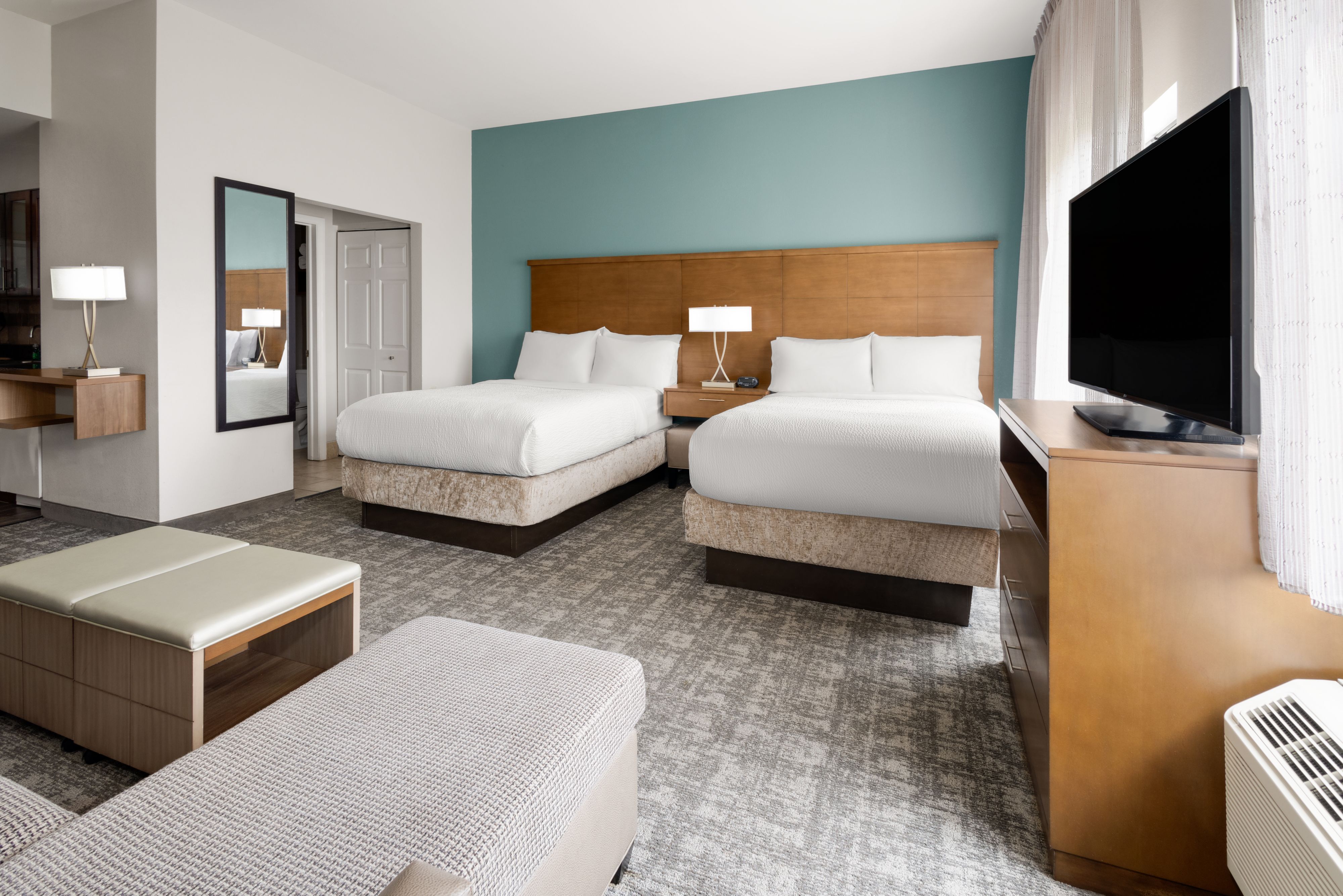 image Well-lit studio featuring double beds and a dedicated workspace.