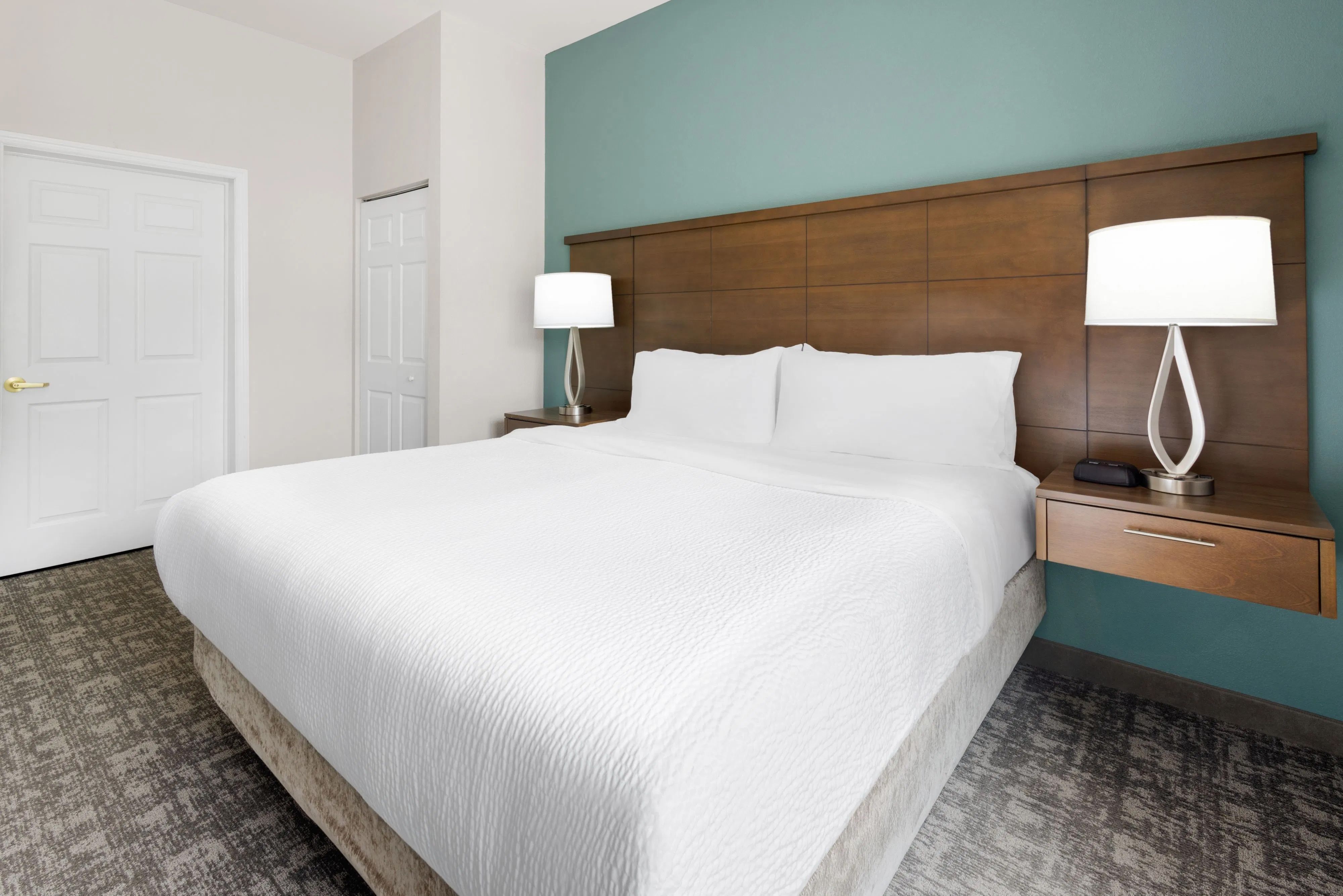 image Cozy bedroom with pristine white linens and warm bedside lighting.