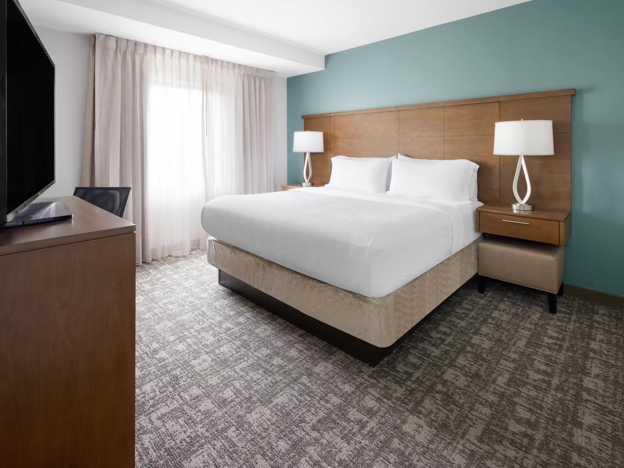 image King bed with flat-screen TV in the master bedroom — work desk nearby for those mixing business and leisure