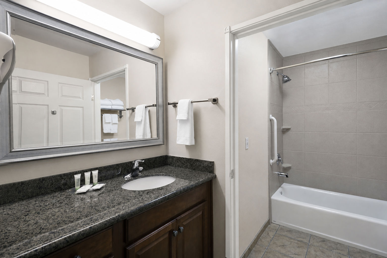 image Accessible bathroom with safety grab bars and a convenient tub.