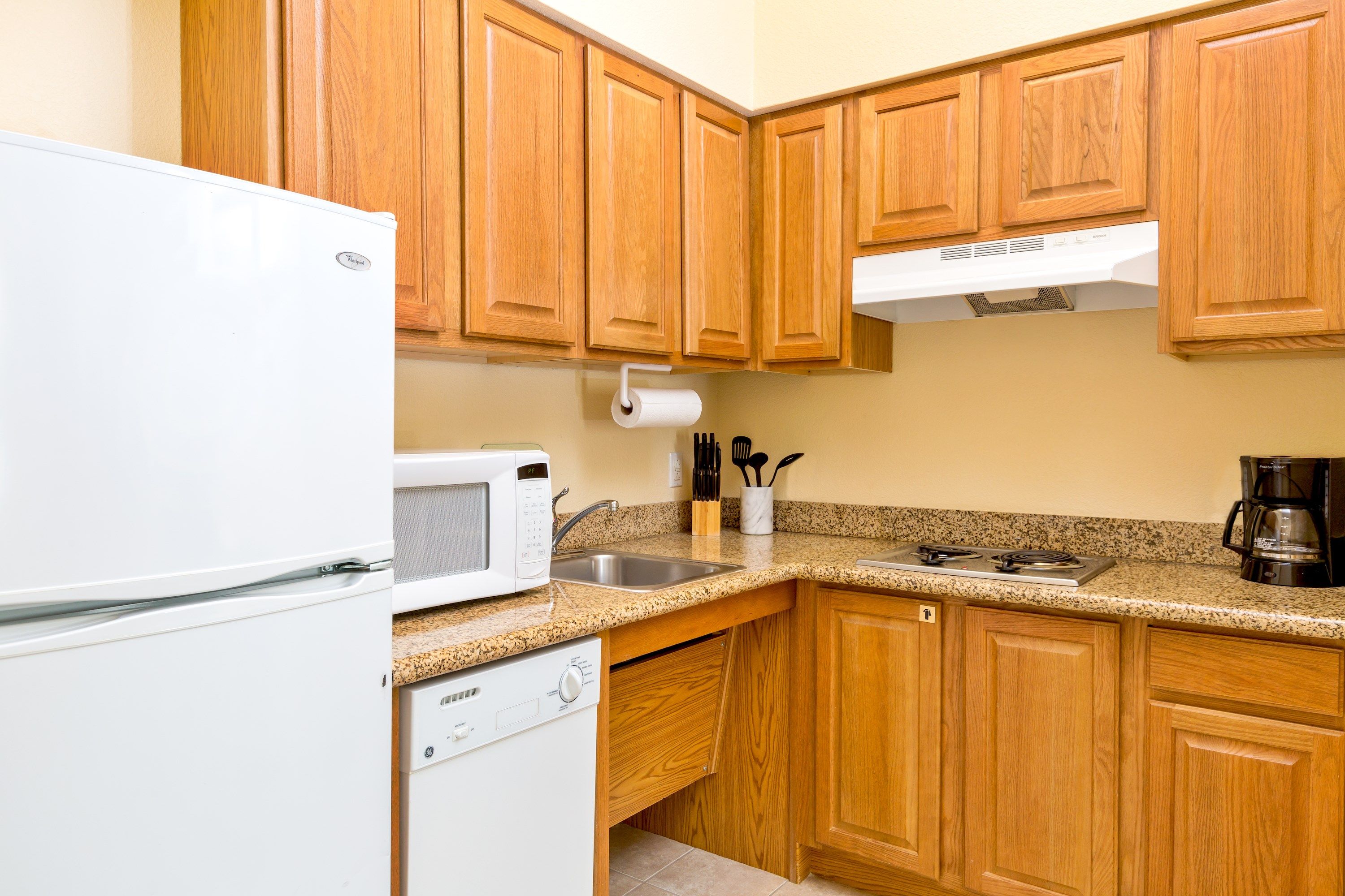 image Fully equipped kitchen with refrigerator, microwave, dishwasher, stove, sink, coffee maker, and cooking utensils