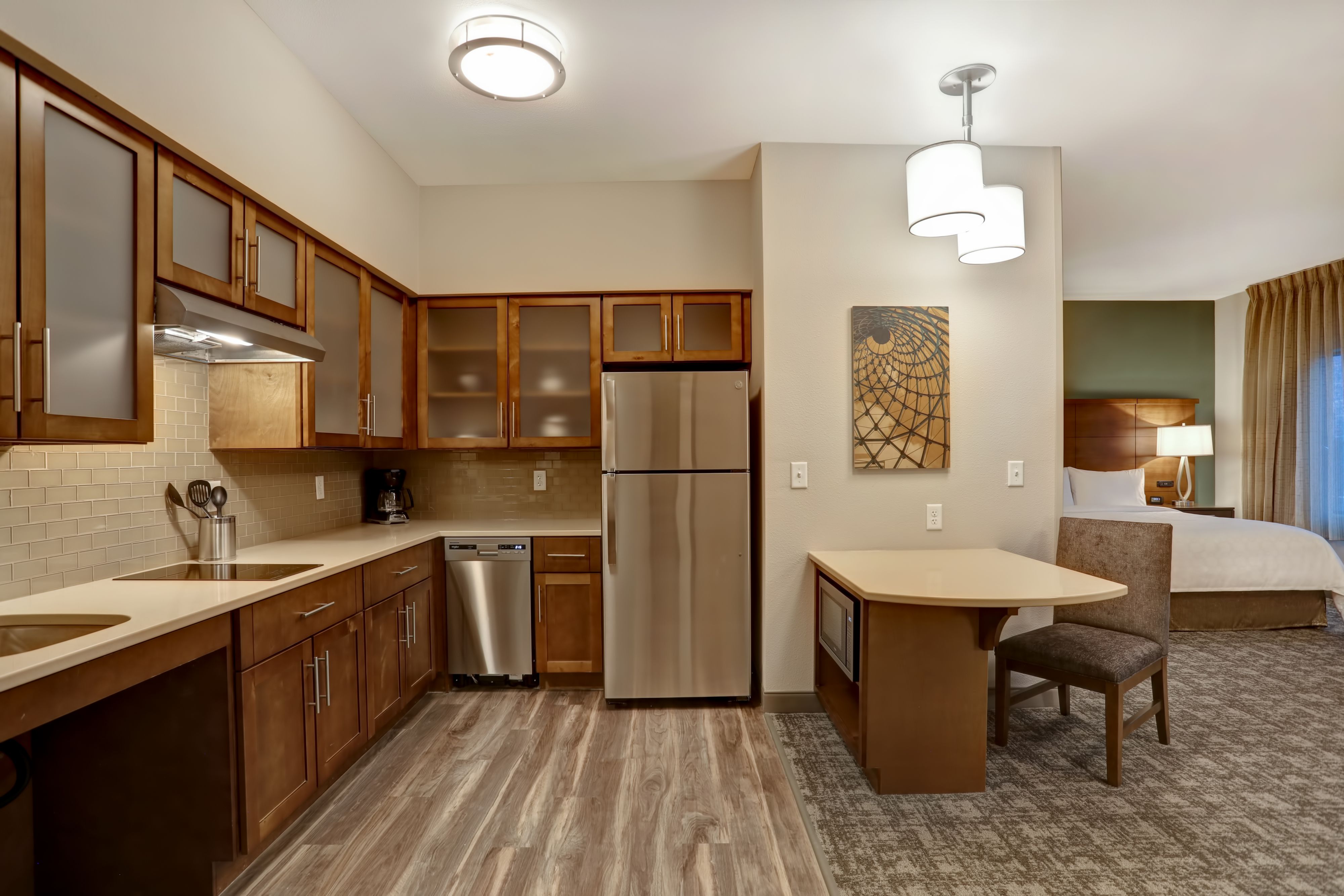 image Fully equipped kitchen with stainless steel appliances and counter seating.
