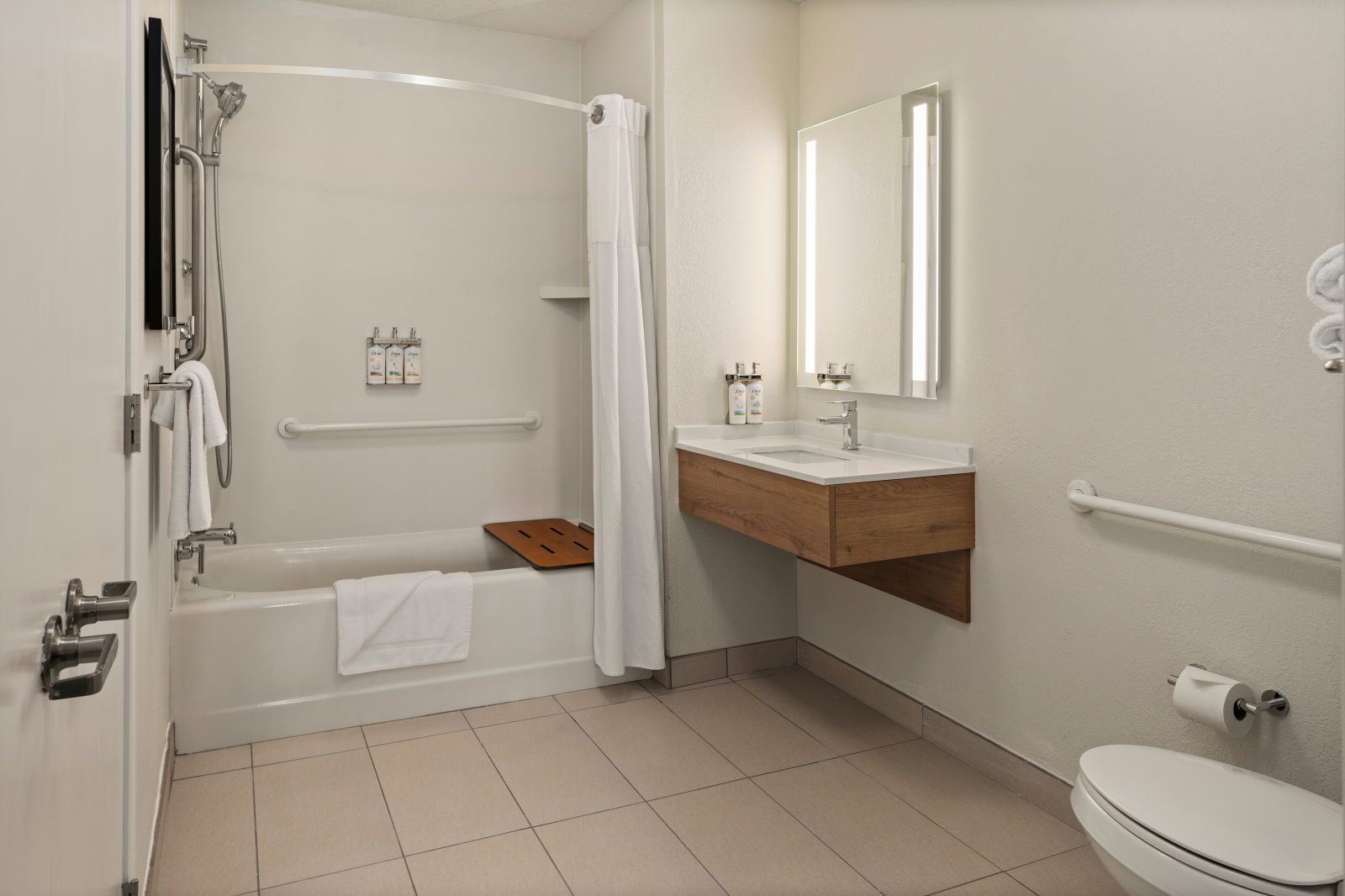 image Accessible bathroom with tub, shower, sink, and mirror.