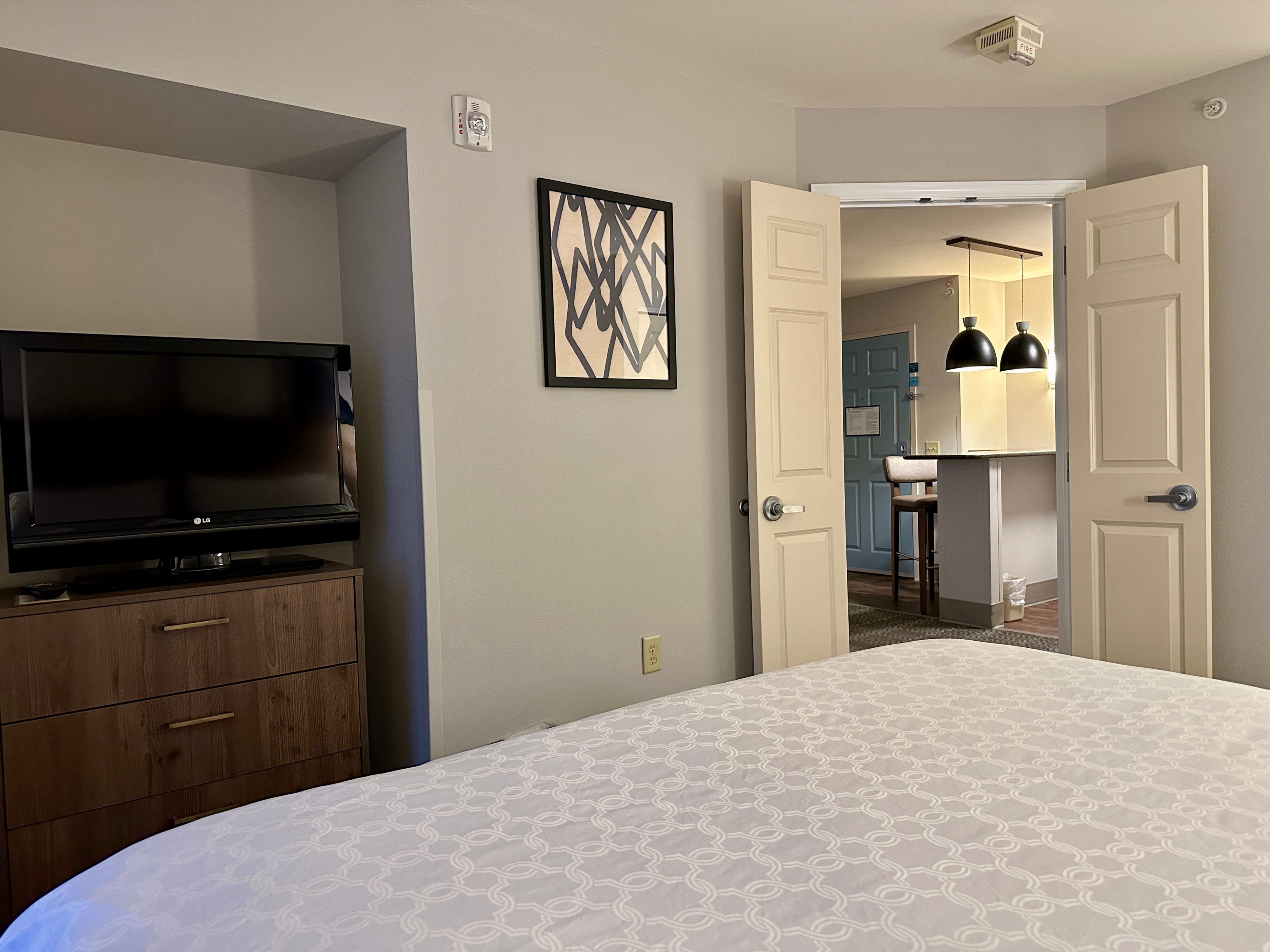 image Suite bedroom with flat-screen TV and warm lighting.
