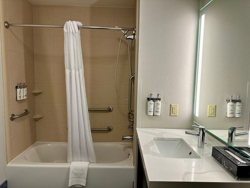 image Accessible bathroom with walk-in shower, tub, and grab bars.
