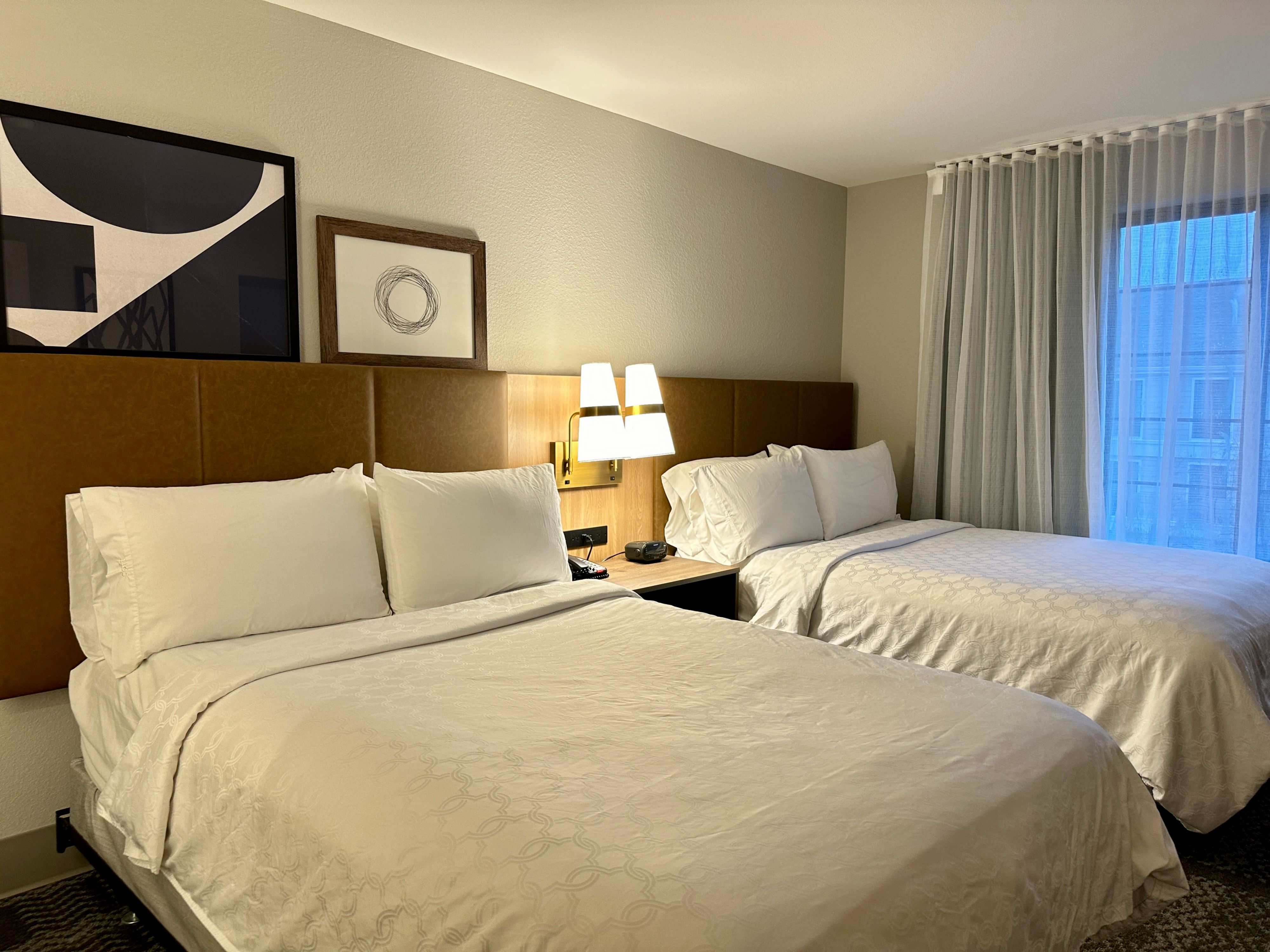 image Two-bedroom suite sleeping area with modern decor.