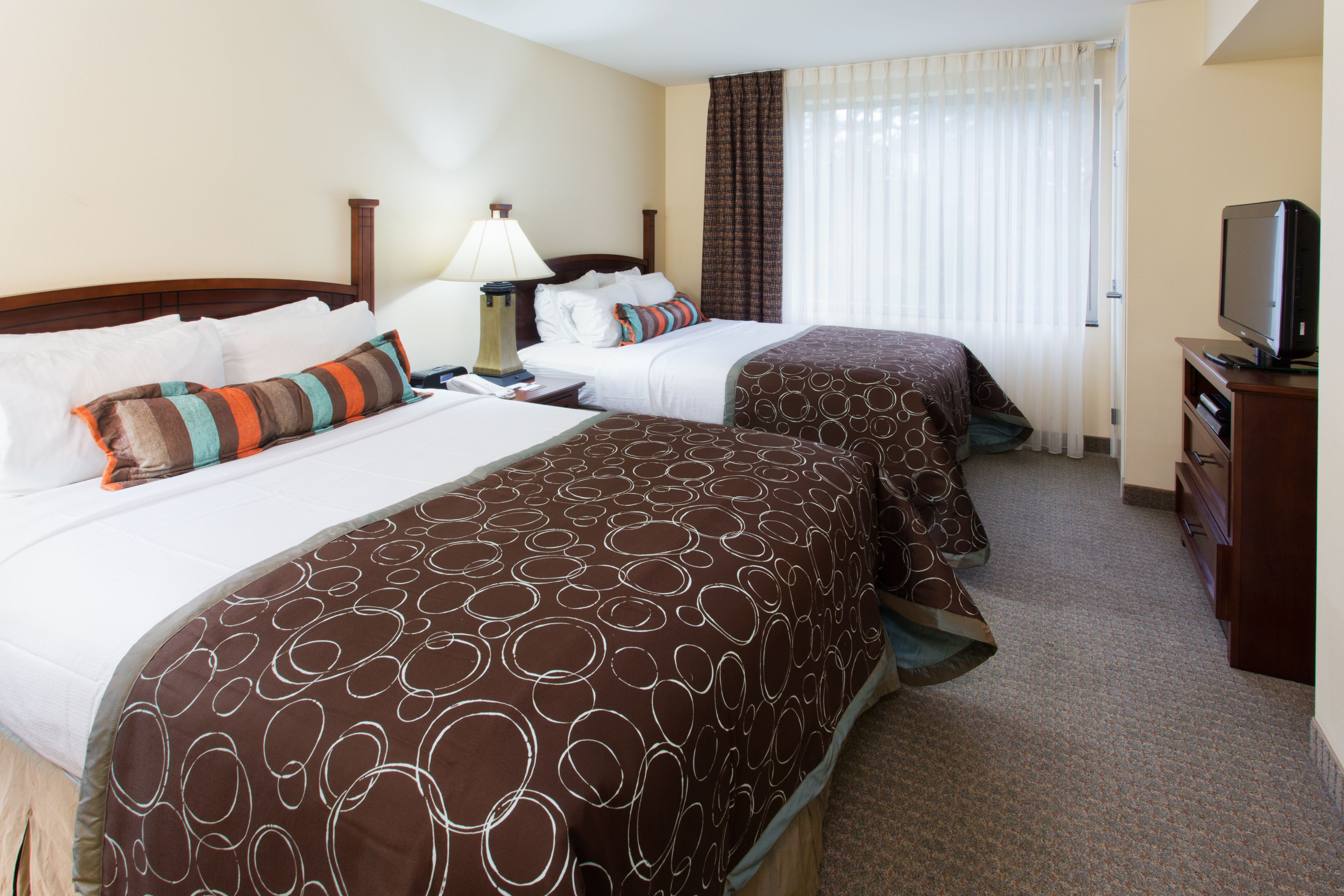 image Bright room with two beds and decorative pillows.