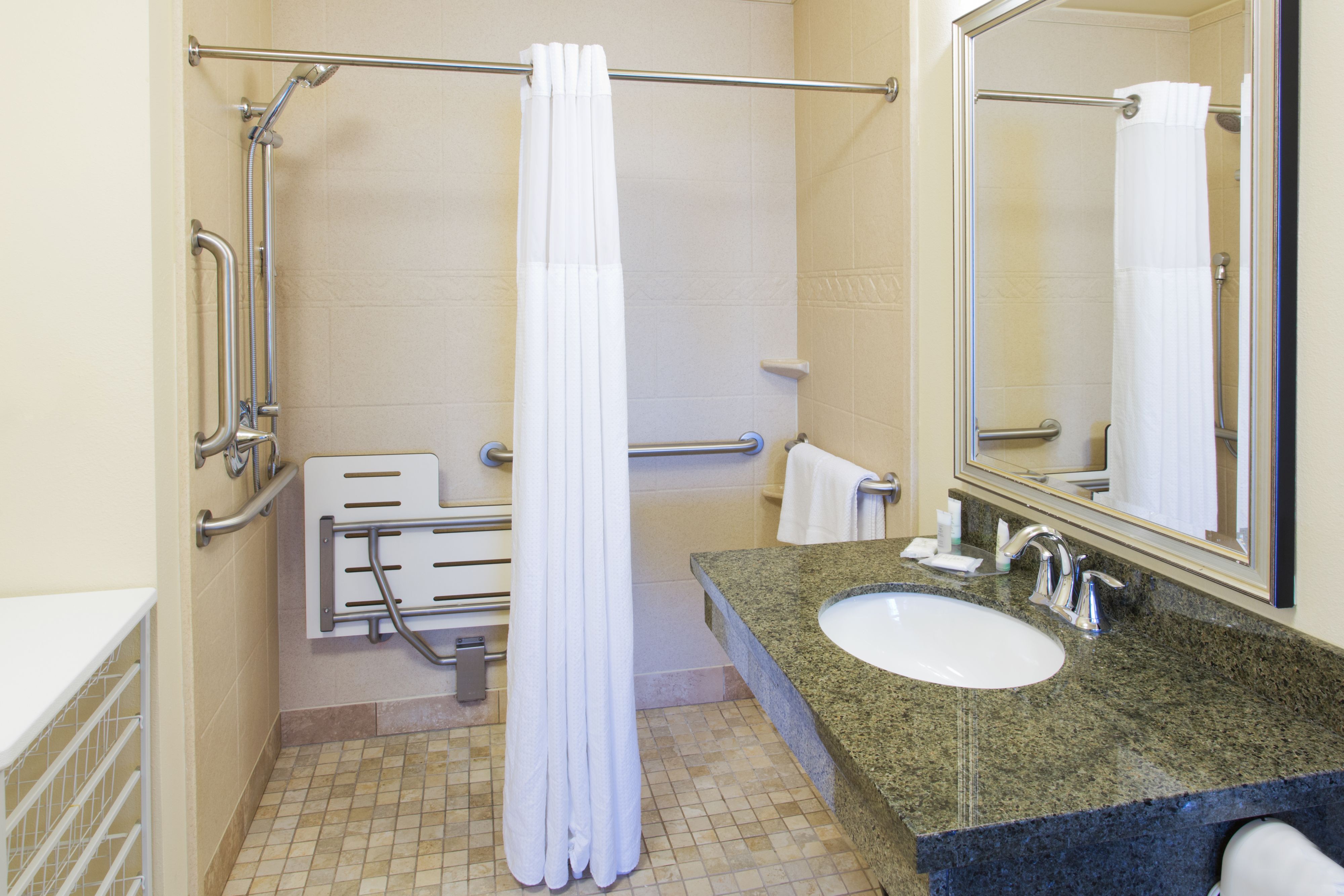 image Bathroom featuring a shower, sink, and safety grab bars.
