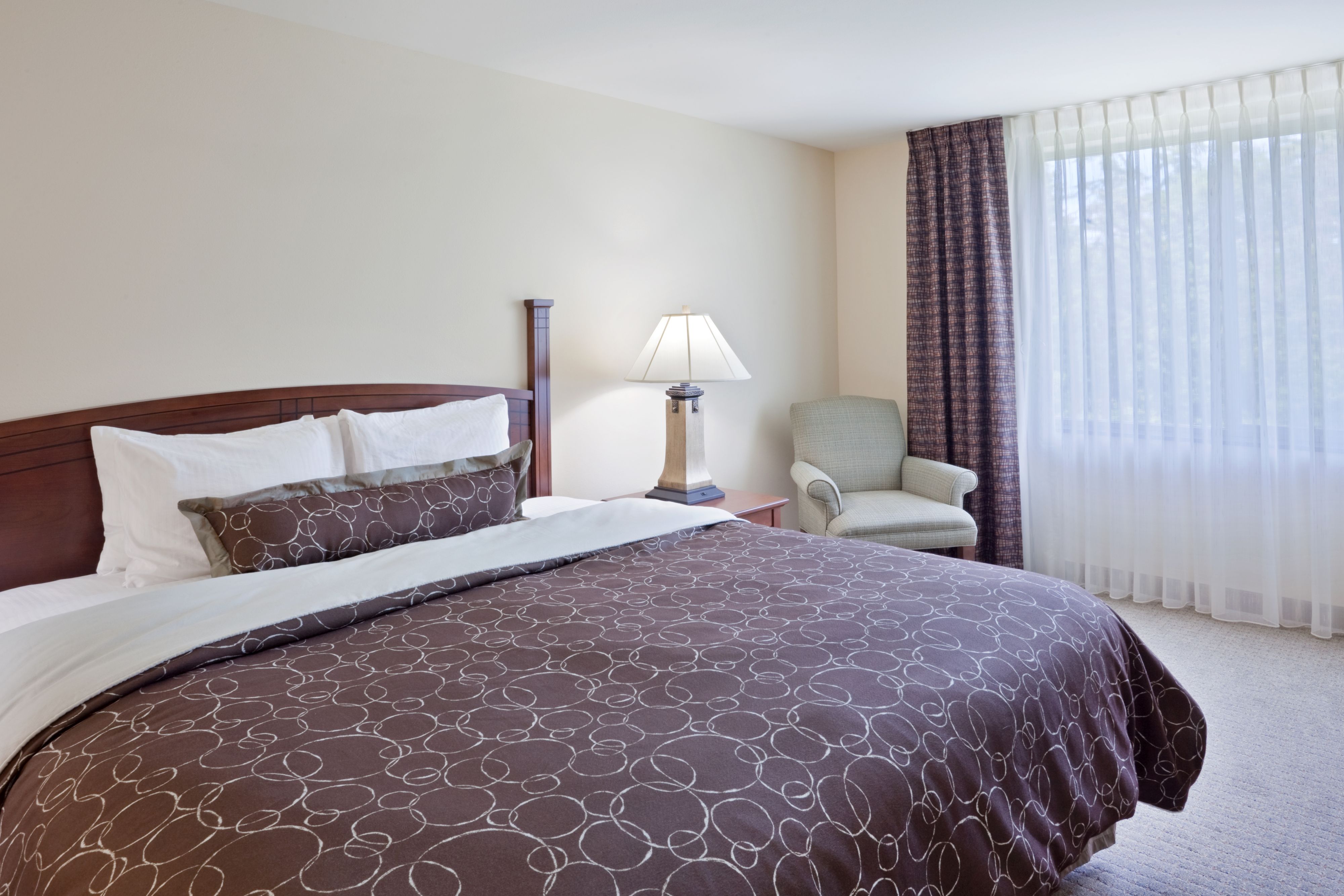 image Cozy bedroom featuring a large bed and seating area.