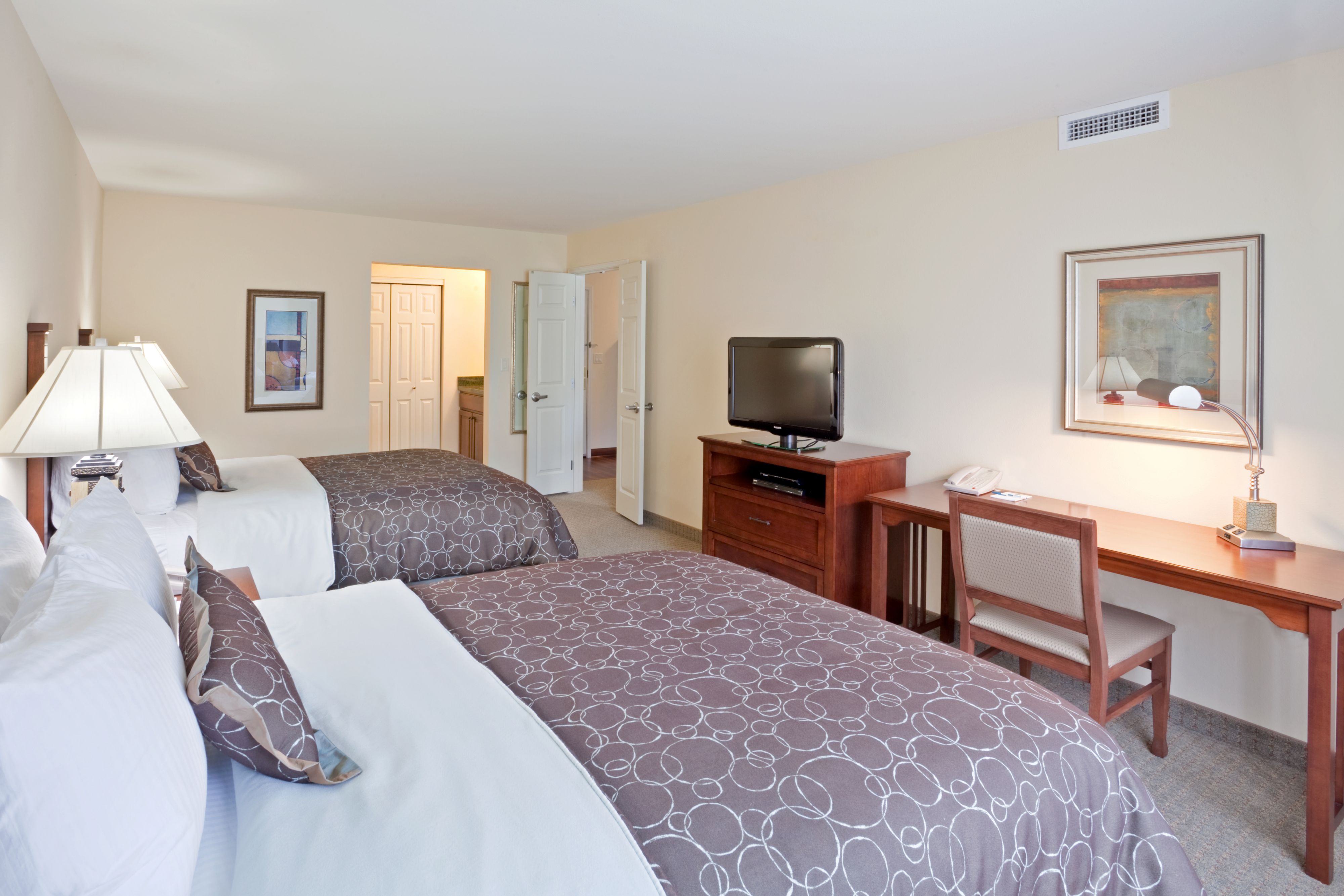 image Two beds side by side with a writing desk and TV.