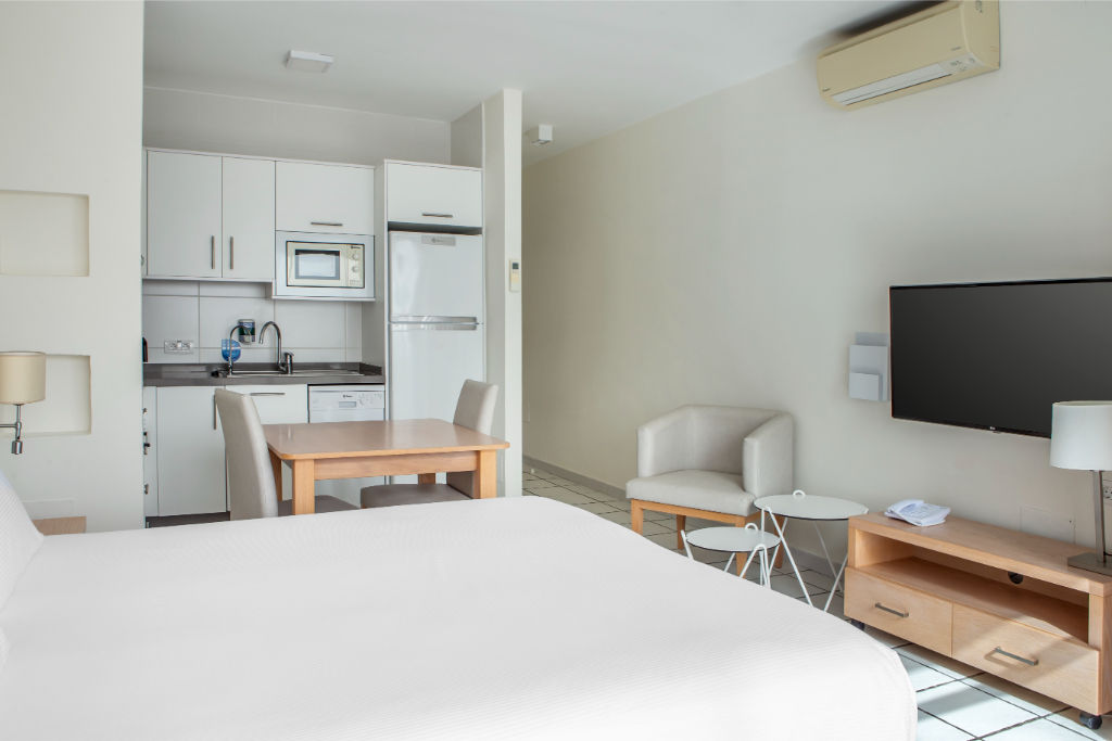 image Comfortable bedroom with integrated living space, featuring a large bed and a relaxing lounge area.