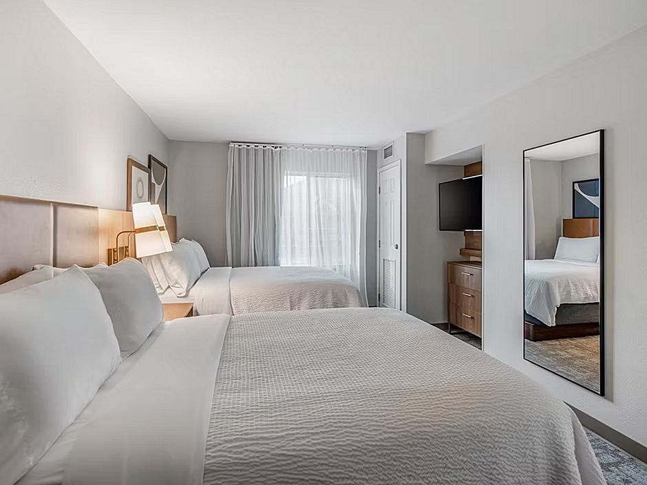 image Sleep well in this spacious bedroom with two double beds and natural light streaming in.