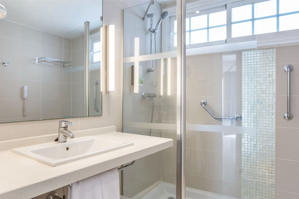 image Modern and well-lit bathroom with a walk-in shower, designed for a refreshing and rejuvenating experience.