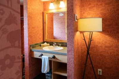 The bathroom features warm and inviting decor along with lovely wood touches.
