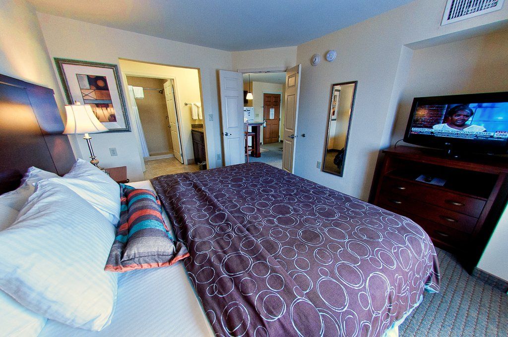 image Wake up refreshed in a plush king-sized bed, with a cozy design and a view to the inviting living area.