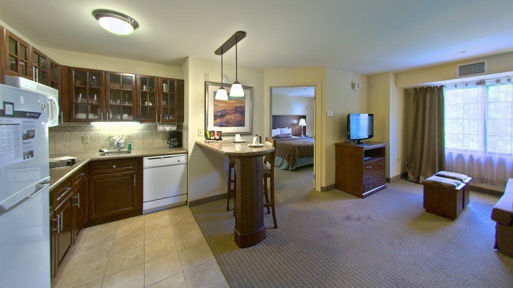 image Cook up a delicious meal in your fully equipped kitchenette, with stylish dark cabinetry and bar seating for a cozy dining experience.