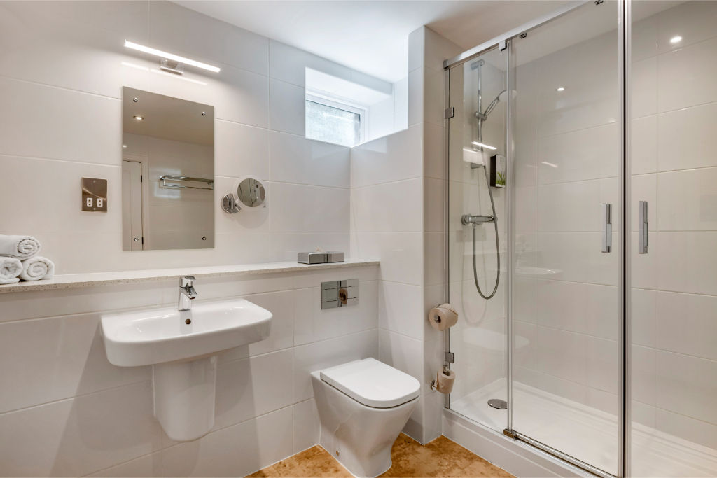 image Modern bathroom with sleek fixtures and a walk-in shower.