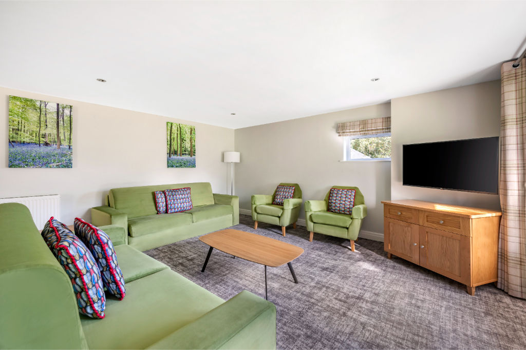 image Open-plan living room with garden views and cozy fireplace.