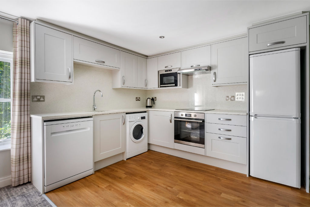 image Sleek white kitchen with modern appliances and a welcoming feel.