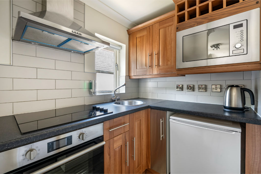 image A practical kitchen space with essential appliances and storage options.