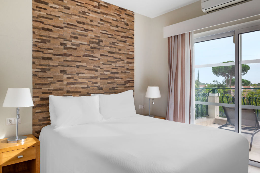 image Bedroom with a comfortable bed and a textured accent wall.