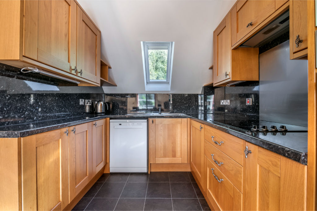 image Kitchen with countertops and wooden cabinetry, ready for culinary activities.