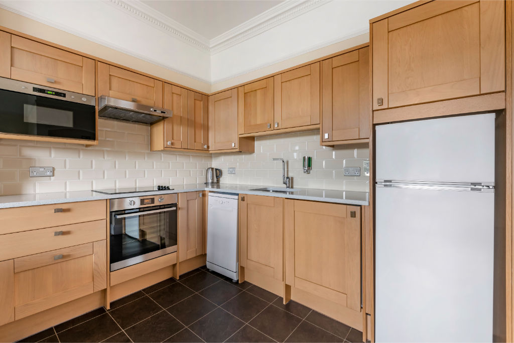 image A practical kitchen space with wooden cabinets and all the necessary appliances.