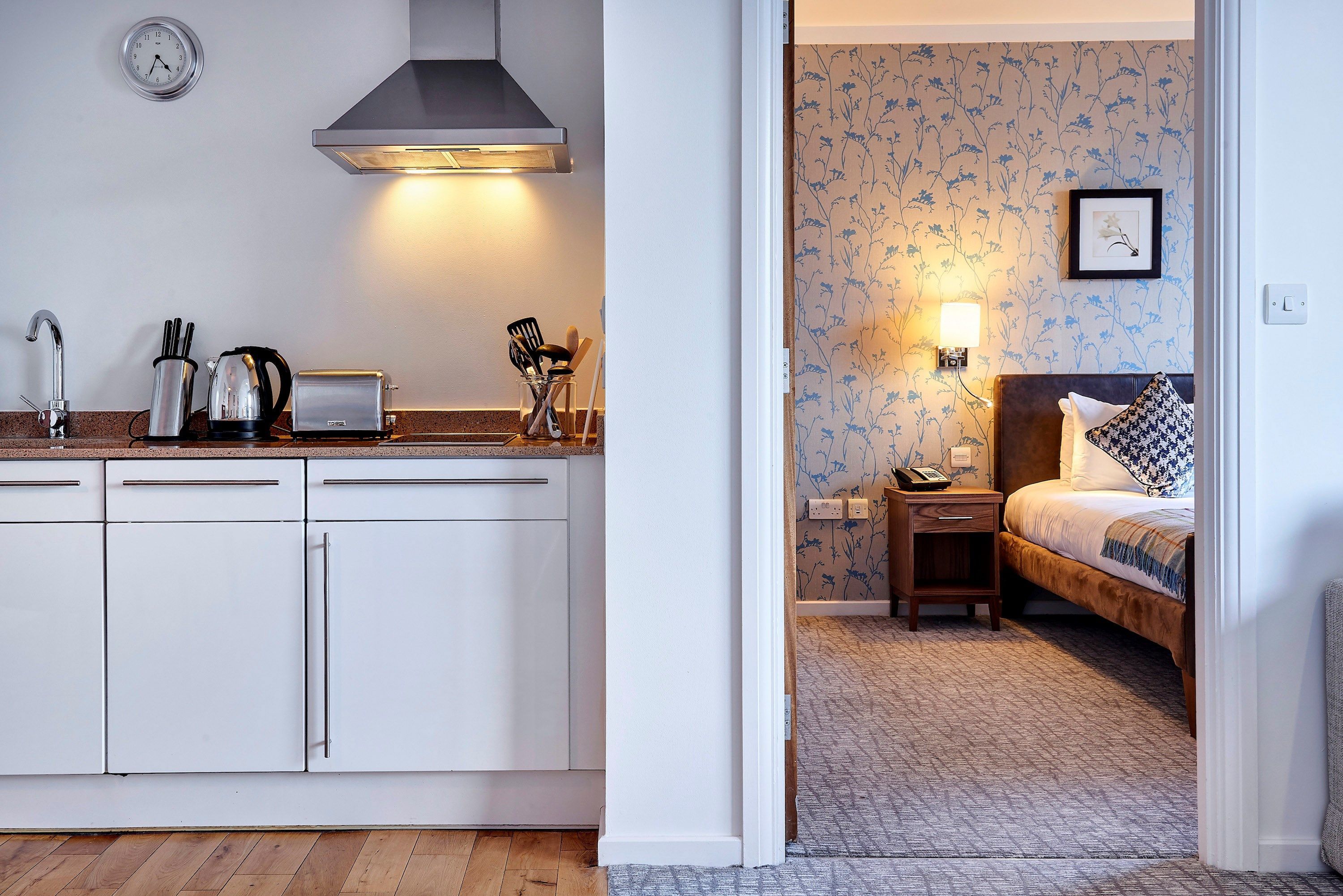 image Kitchen area with modern appliances and adjacent bedroom view.