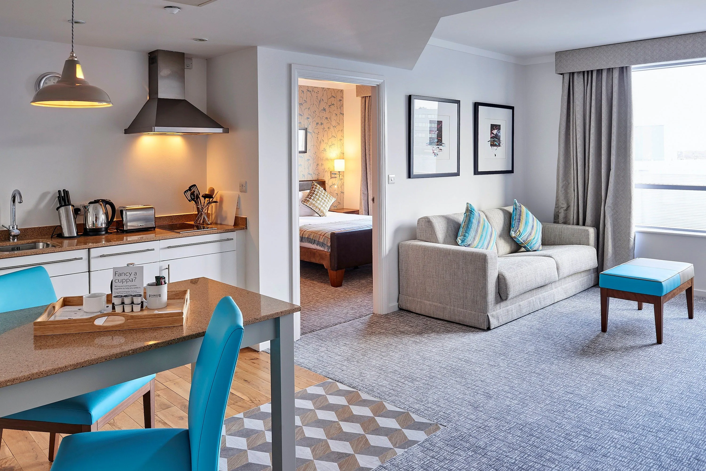 image Spacious suite with kitchen, cozy seating, and inviting open layout.