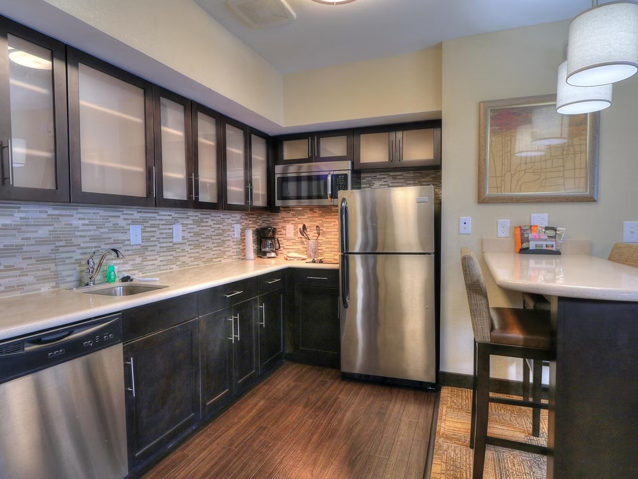 image Full kitchen with stovetop, full-size refrigerator, microwave, and dishwasher — dining table seats the group