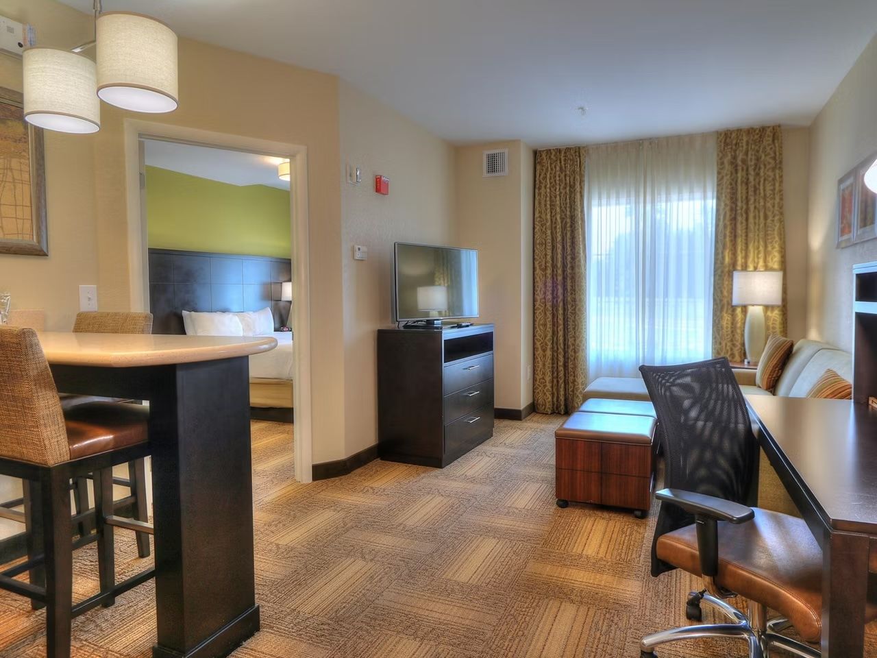 image Living area with pull-out sofa bed, flat-screen TV, and work desk — wide doorways throughout for easy access