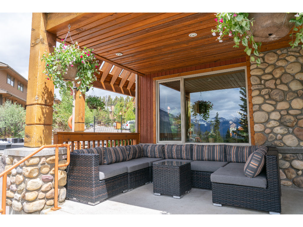 image  Experience the inviting charm of the resort's exterior, blending rustic stonework and natural wood elements with stunning mountain views for a warm, welcoming ambiance.