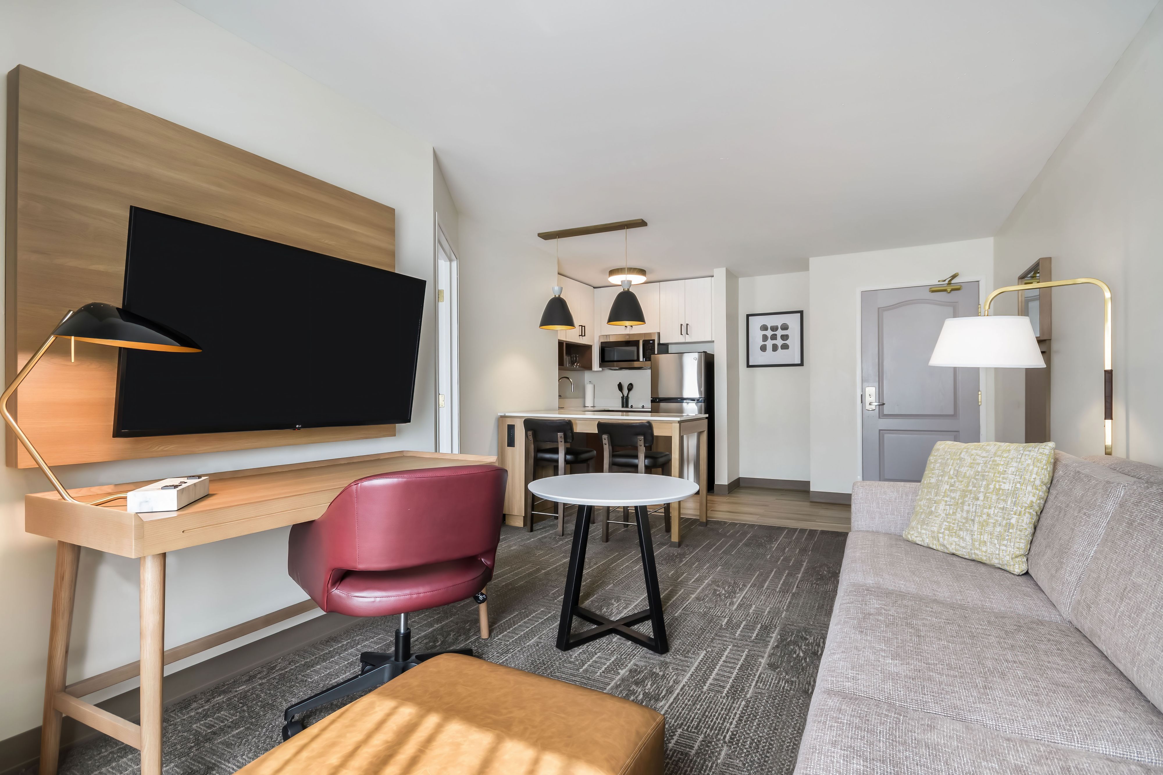 image Open-plan layout with living area, dining table, kitchen, and desk all in one connected space