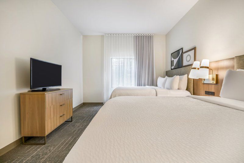 image Second bedroom with flatscreen TV, and sheer-curtained windows