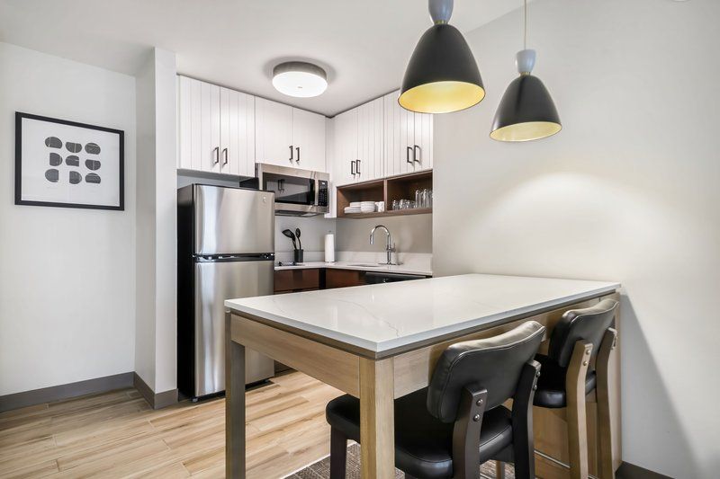 image Fully equipped kitchen with stainless steel appliances, wood-tone cabinets, and a stovetop for home-cooked meals