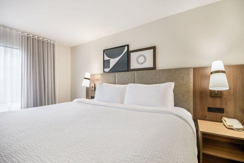 image Cozy bedroom with a plush bed, warm ambiance, and bedside lamp