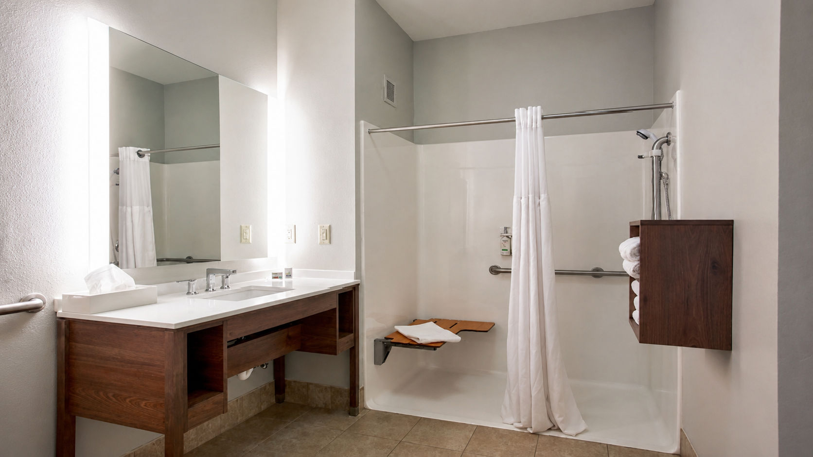 image Accessible bathroom with roll-in shower, sink, and mirror.